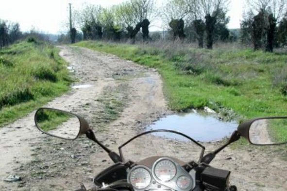 Se o piso da via estiver cheio de buracos, enquanto condutor de motociclo, devo: — pergunta R11Q0253 do exame de código IMT