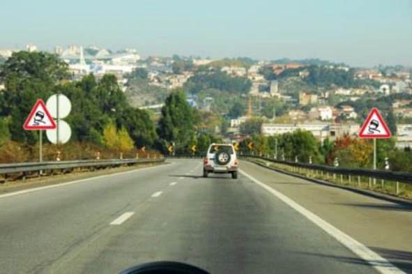 Na presença deste sinal de perigo devo circular o mais afastado possível da berma. — pergunta R1Q0299 do exame de código IMT