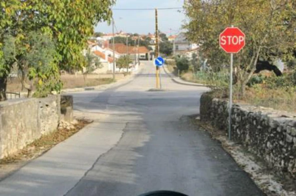 Como deve proceder o condutor de um veículo que transite em serviço de urgência perante o sinal vertical de fundo vermelho? — pergunta R6Q0249 do exame de código IMT